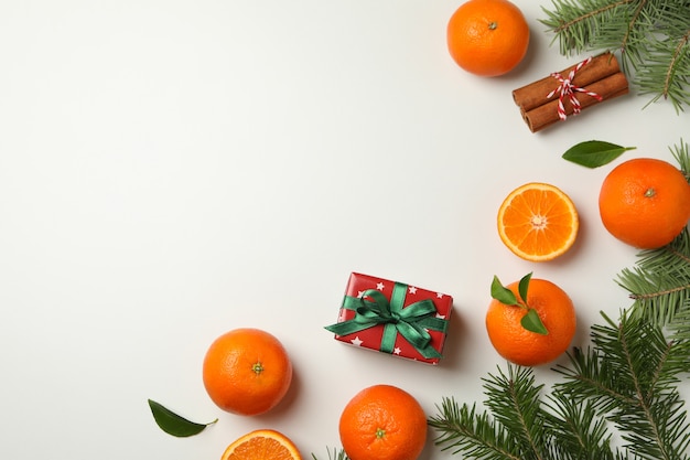 Mandarinas, ramas de pino, canela y caja de regalo en blanco