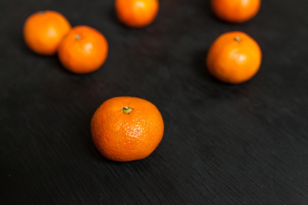 Mandarinas sobre un fondo negro. Mucha fruta fresca - mandarinas.