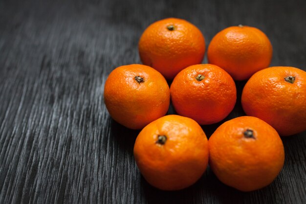 Mandarinas sobre un fondo negro. Mucha fruta fresca - mandarinas.