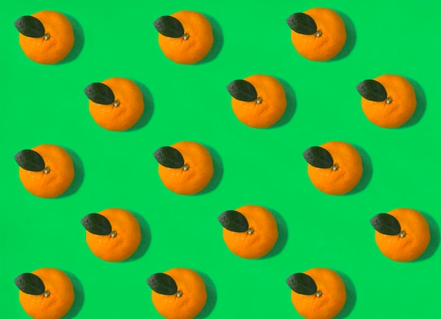 Mandarine auf dem grünen Hintergrund Flache Lage Muster Draufsicht