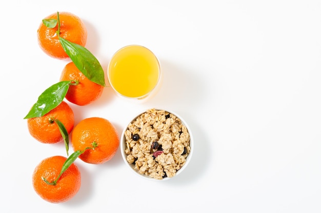 Mandarine, Clementine mit Blättern und ein Glas Orangensaft mit weißem Hintergrund. Ansicht von oben.