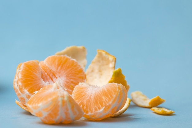 Mandarine geschält und in Segmente geteilt, auf blauem Grund, gesunde Zitrusfrüchte