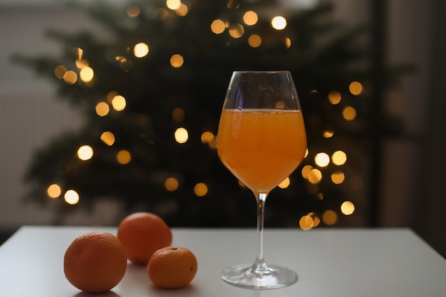 Mandarine oder Orangensaft mit Mandarinen auf dem Weihnachtsbaumhintergrund
