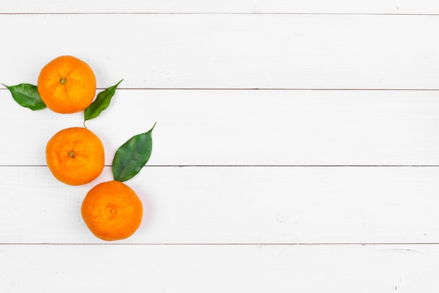 Mandarinen auf einem weißen hölzernen Hintergrund