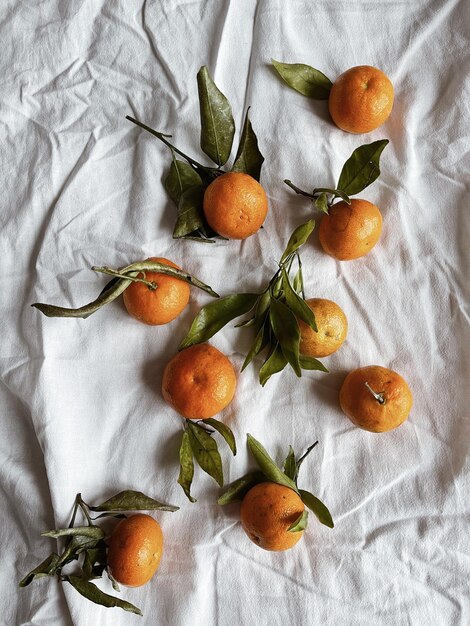 Mandarinen auf neutralem, zerknittertem Leinentuch Flache Ansicht von oben