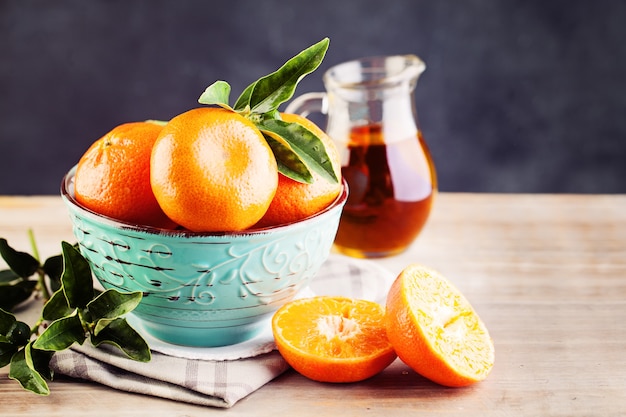 Mandarinen-Frucht mit grünen Blättern auf Vintage-Hintergrund