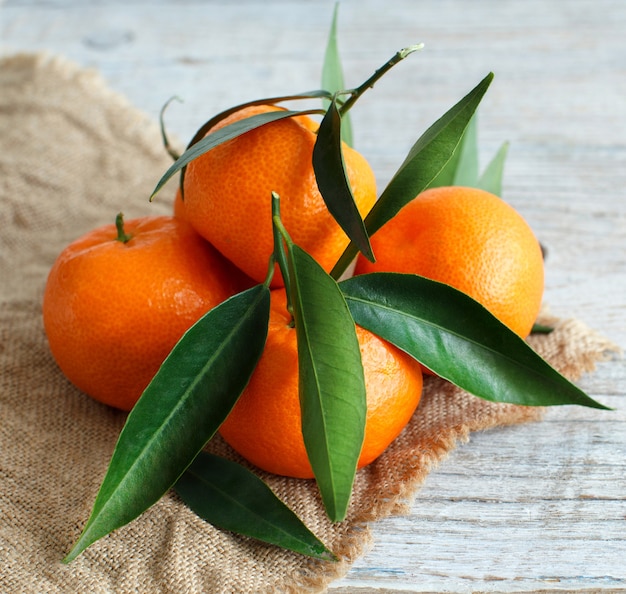 Mandarinen mit blättern auf einem holztisch schließen oben