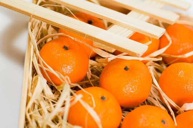 Mandarinen mit Stroh in Holzkiste