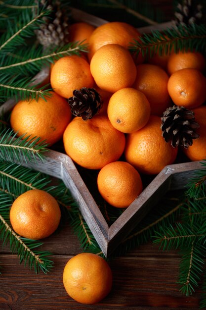 Mandarinen mit Weihnachtsdekoration auf rustikaler Holzkiste