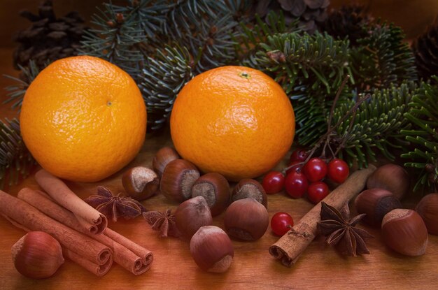 Mandarinen Tannenzweige Zimt und Nüsse auf einem Holztisch Dunkler Hintergrund Heller Pinsel