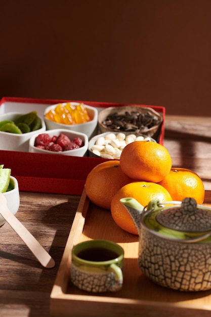 Mandarinen Tasse Tee und kandierte Früchte und Nüsse auf dem Tisch serviert für die Feier des neuen Mondjahres