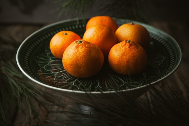 Mandarinen und Äste auf Holztisch. Mandarinenfrüchte