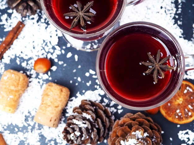 Foto mandarinen- und zweigbaum mit zwei gläsern heißem glühwein mit orangen und gewürzen.