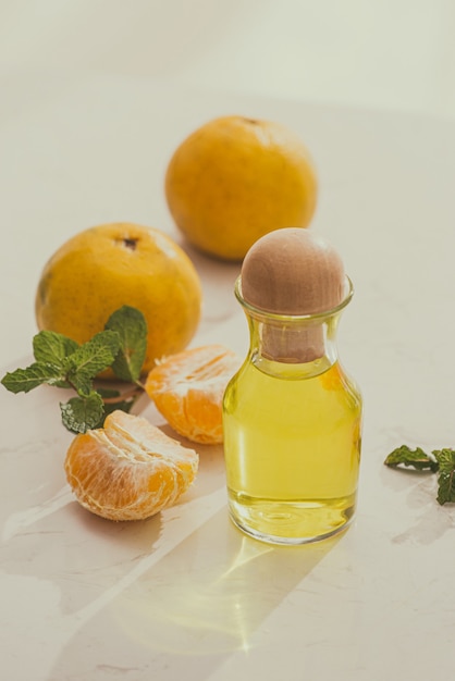 Mandarinenöl auf dem Tisch auf hellem Hintergrund