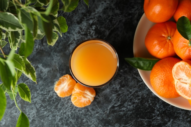 Mandarinensaft und Zutaten auf schwarzem Rauchtisch