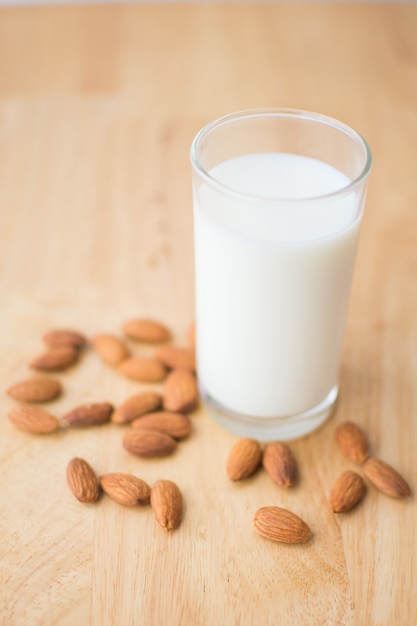 Mandel und Milch auf Holztisch. Weicher Fokus.