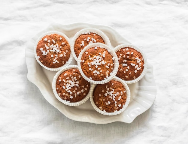 Mandelmehlmuffins mit Perlzucker auf einem Teller auf einem hellen Hintergrund