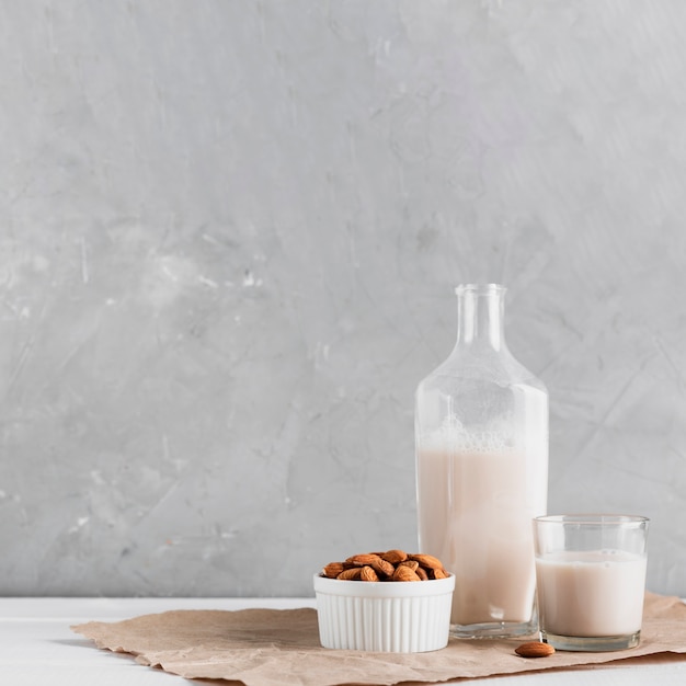 Mandelmilch im Glas und in der Flasche mit Mandeln