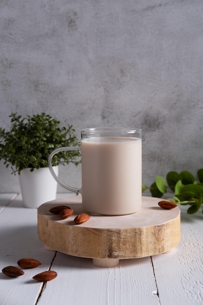 Mandelmilch mit Mandeln auf einem weißen Holztisch