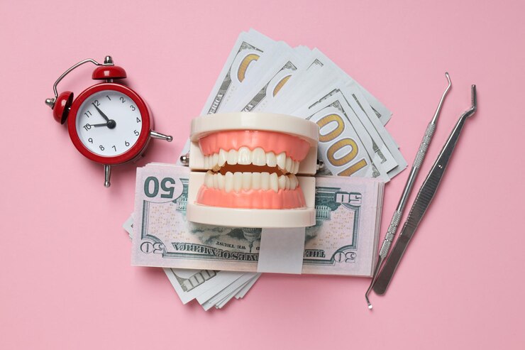 Mandíbula decorativa del reloj y dinero en la vista superior de fondo rosa