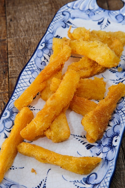 Mandioca frita en plato de porcelana blanca y azul