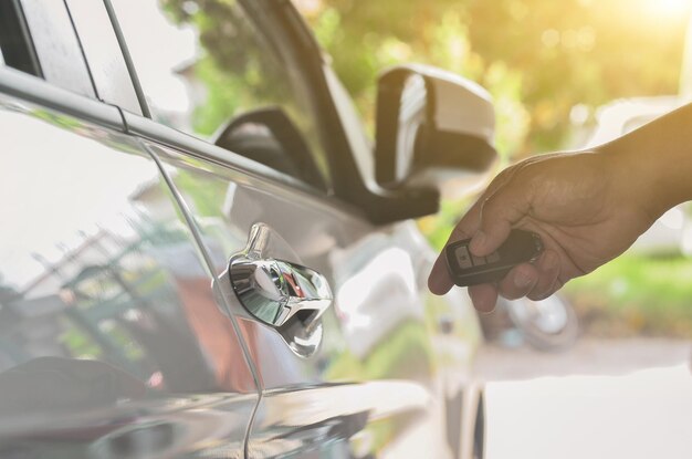 Mando a distancia del coche Mano sujetando la llave inteligente del mando a distancia para bloquear las puertas del coche