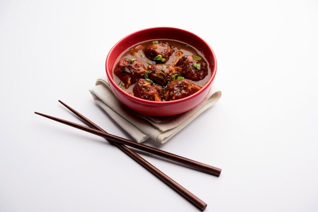 Mandschurisches Gemüse oder Hühnchen mit Soße - Beliebtes indisches Essen, serviert in einer Schüssel mit Stäbchen