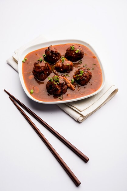 Mandschurisches Gemüse oder Hühnchen mit Soße - Beliebtes indisches Essen, serviert in einer Schüssel mit Stäbchen