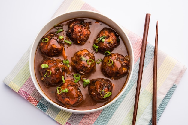 Mandschurisches Gemüse oder Hühnchen mit Soße - Beliebtes indisches Essen, serviert in einer Schüssel mit Stäbchen