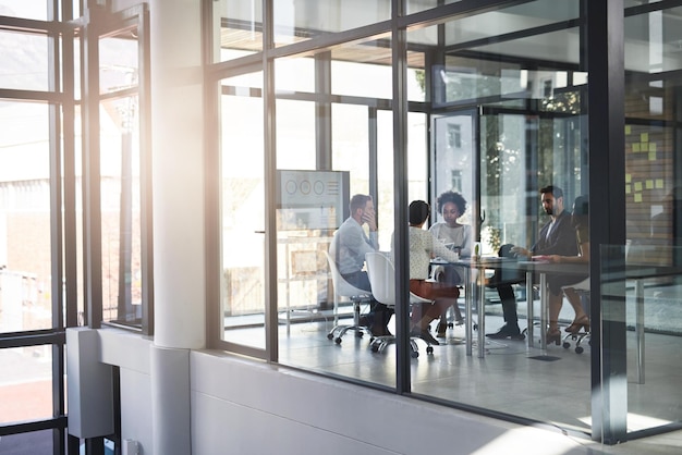 Manejar sus negocios en la sala de juntas Toma completa de un grupo de empresarios reunidos en la sala de juntas