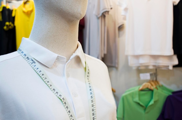 Manequim com camisa branca e fita métrica de cintura em loja de roupas