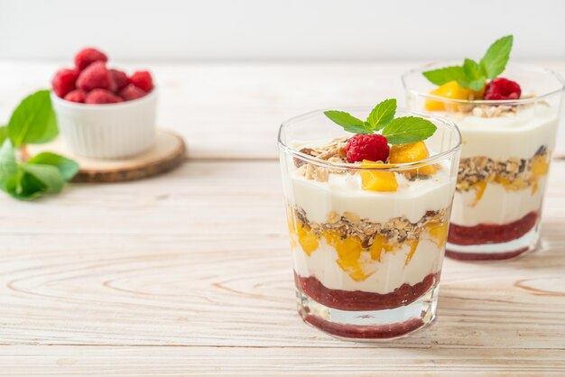 manga fresca caseira e framboesa fresca com iogurte e granola. estilo de comida saudável