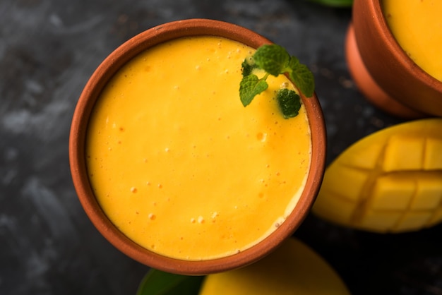 Manga Lassi ou iogurte, popular bebida indiana de verão servida em copo com fruta Alphonso Aam inteira, foco seletivo