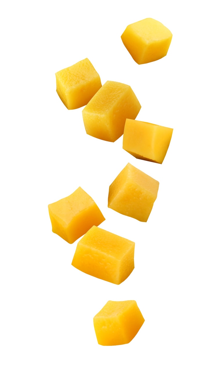 Mangas caindo isoladas em um fundo branco com um traçado de recorte. cubos de frutas no ar.