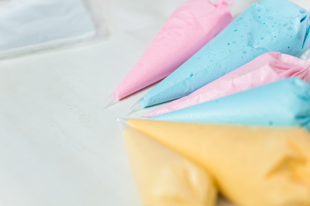 Mangas pasteleras con glasa real en colores pastel para decorar galletas de azúcar de Pascua.