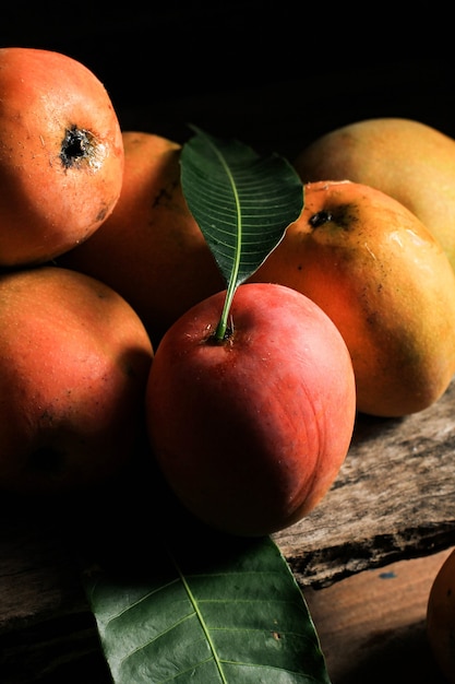 Mangga Gedong Gincu - Reife Mango Varian, hauptsächlich angebaut in Majalengka und Cirebon, West Java. Gedong Gincu Mango hat rote Haut und duftendes Aroma. Auf rustikalem Brett mit Holzstruktur