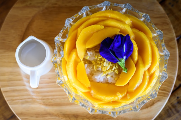 Mango arroz con leche de coco en la mesa de madera, popular postre tailandés tradicional