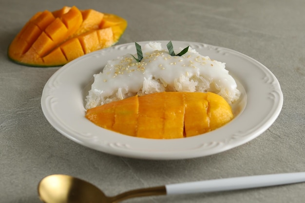 El mango con arroz pegajoso es un postre típico tailandés elaborado con arroz glutinoso y salsa de leche de coco.