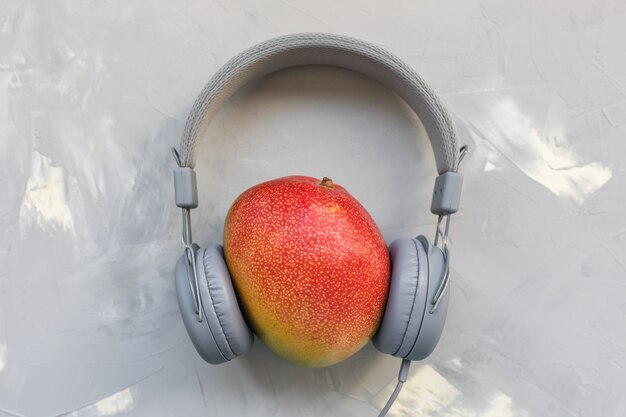 Mango y auriculares sobre fondo gris