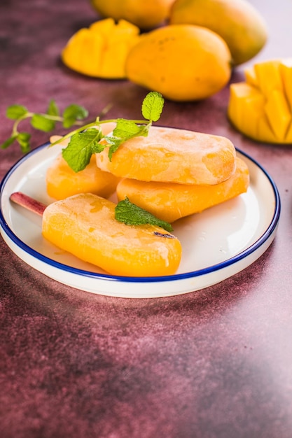 Mango-Bananen-Eis am Stiel mit frischen Früchten flach von oben