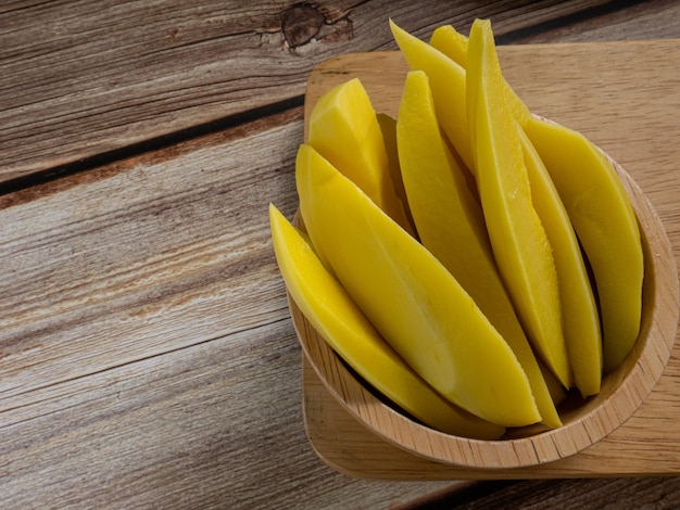 El mango en escabeche de Tailandia en un recipiente sobre la mesa de madera para el contenido alimentario.