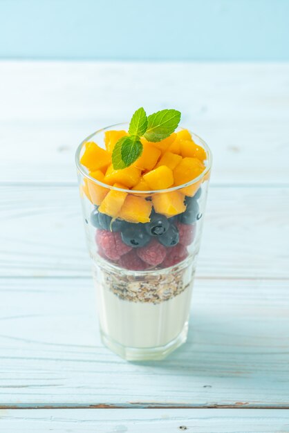 mango, frambuesa y arándano caseros con yogur y granola - estilo de comida saludable