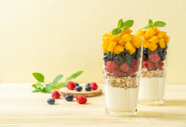 mango, frambuesa y arándano caseros con yogur y granola - estilo de comida saludable