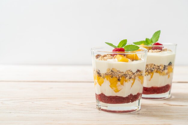 mango fresco casero y frambuesa fresca con yogur y granola - estilo de comida saludable