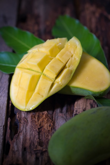 Mango fruta y cubos de mango en la mesa de madera