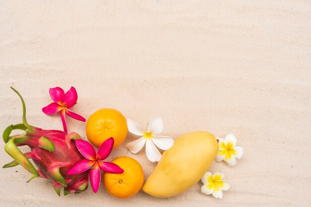 Mango y fruta del dragón en la playa de arena