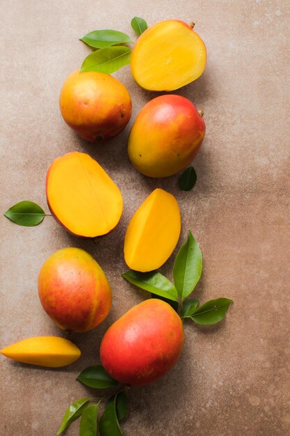 Mango-Hintergrunddesign-Konzept Draufsicht auf frisches Mango-Fruchtmuster mit Blättern auf dem Tisch