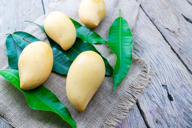 Mango con hojas sobre fondo de mesa de madera