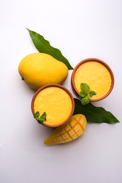 Mango Lassi o yogur, bebida de verano popular indio servido en vaso con toda la fruta Alphonso Aam, el enfoque selectivo