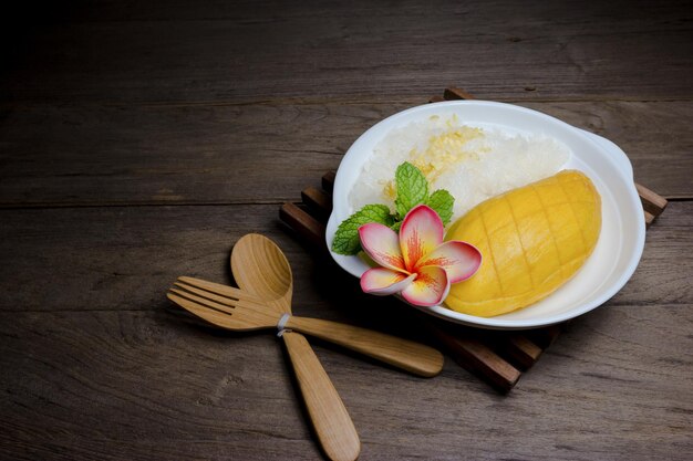 Foto mango maduro com arroz pegajoso em fundo de madeira